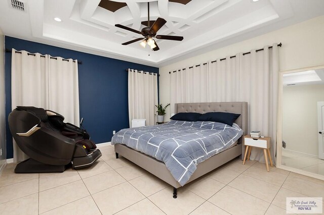 tiled bedroom featuring ceiling fan, a raised ceiling, and coffered ceiling