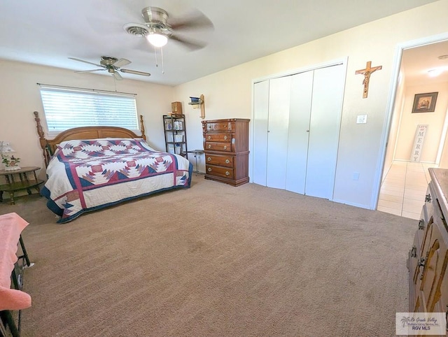 carpeted bedroom with ceiling fan and a closet