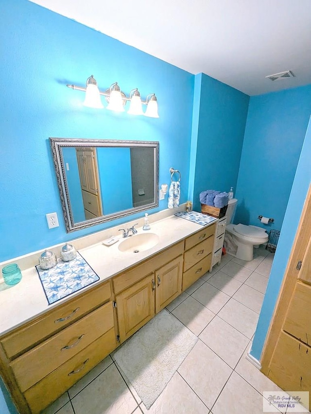 bathroom with tile patterned flooring, vanity, and toilet