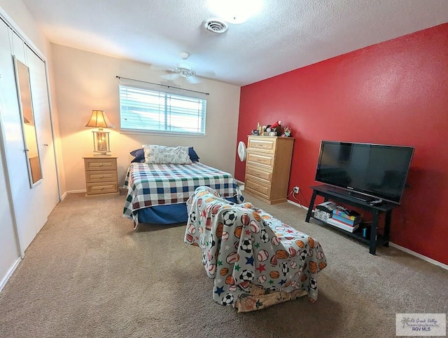 bedroom featuring a textured ceiling, carpet floors, and a closet