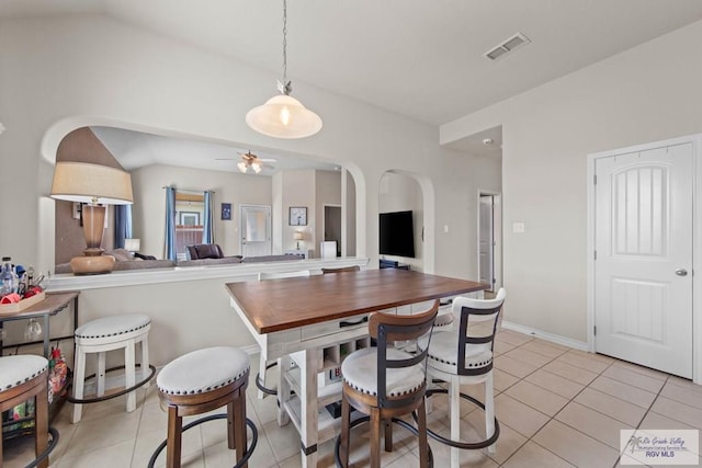 dining area featuring light tile patterned floors, visible vents, arched walkways, and ceiling fan