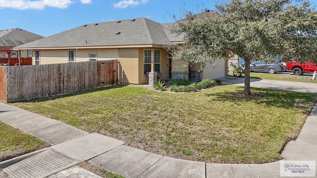 exterior space featuring concrete driveway, an attached garage, fence, a front lawn, and stucco siding