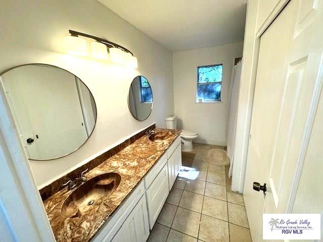 bathroom with vanity, toilet, and tile patterned flooring