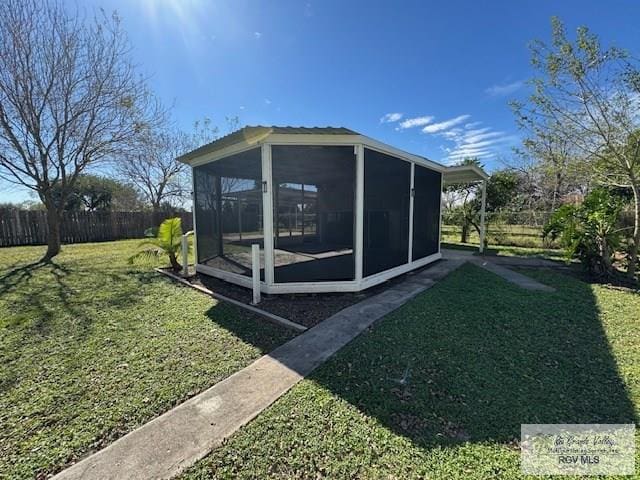 view of side of property with a yard and a sunroom