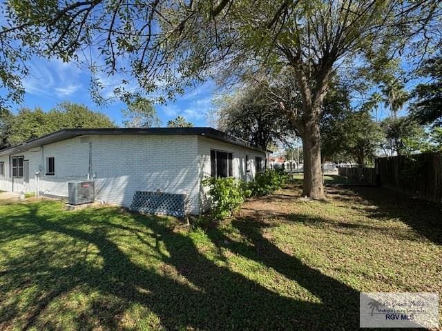 view of side of property with a yard and central AC unit