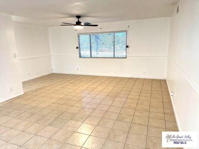 tiled empty room with ceiling fan