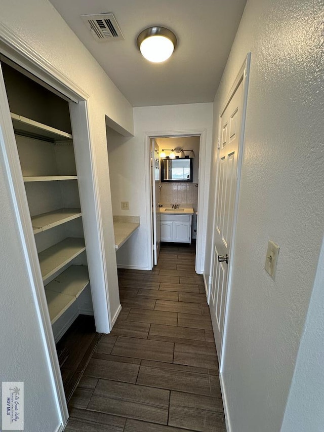 hallway featuring sink and dark hardwood / wood-style floors