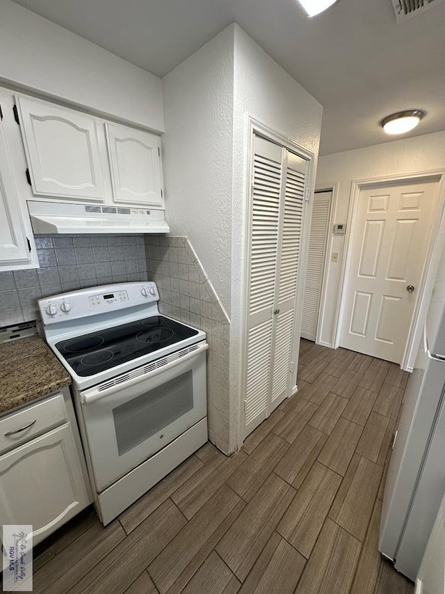 kitchen with white cabinets, decorative backsplash, and white electric stove