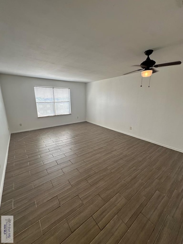 empty room with ceiling fan and dark hardwood / wood-style flooring