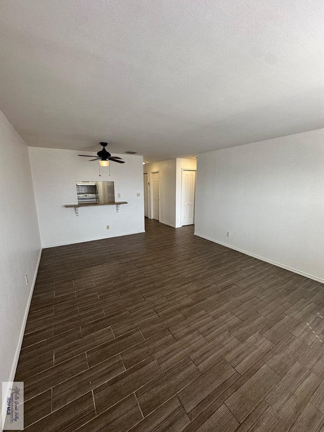 unfurnished living room with dark hardwood / wood-style floors, ceiling fan, and a textured ceiling