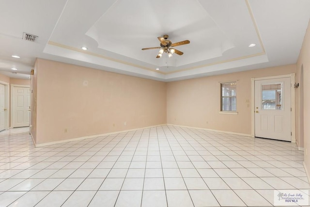 tiled spare room with a raised ceiling and ceiling fan