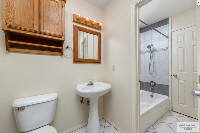 bathroom with tile patterned floors, toilet, and tiled shower / bath combo