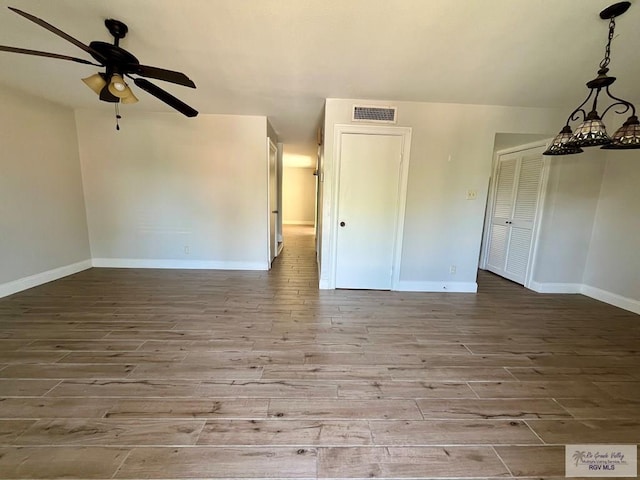 empty room with ceiling fan and light hardwood / wood-style flooring