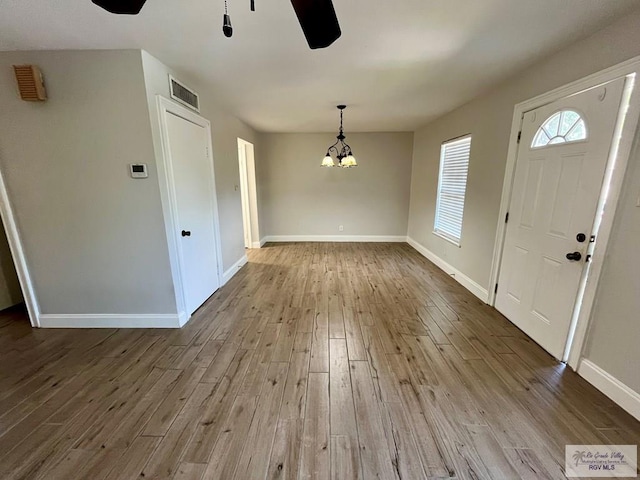 foyer entrance featuring light hardwood / wood-style flooring and ceiling fan with notable chandelier