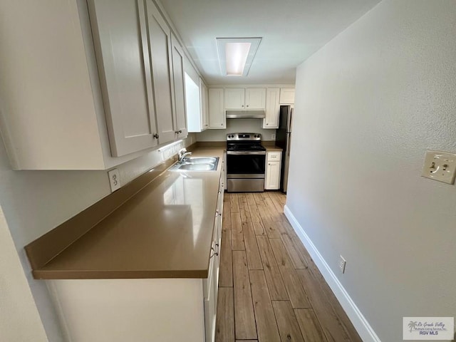 kitchen with white cabinets, stainless steel appliances, light hardwood / wood-style flooring, and sink