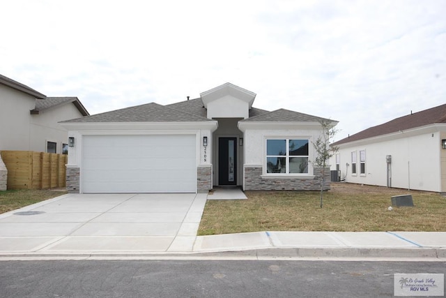 view of front of property featuring a front lawn, central AC unit, and a garage