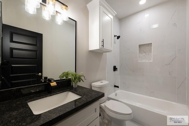 full bathroom featuring toilet, tiled shower / bath, and vanity