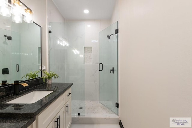 bathroom featuring vanity and a shower with shower door