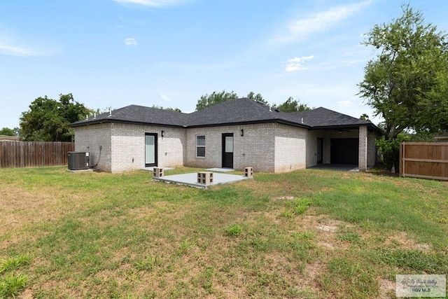 rear view of property with central AC unit, a yard, and a patio area