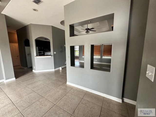 tiled spare room with ceiling fan