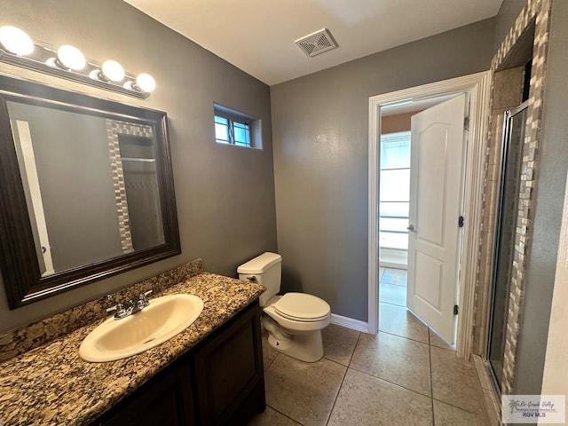 bathroom featuring tile patterned flooring, vanity, toilet, and an enclosed shower