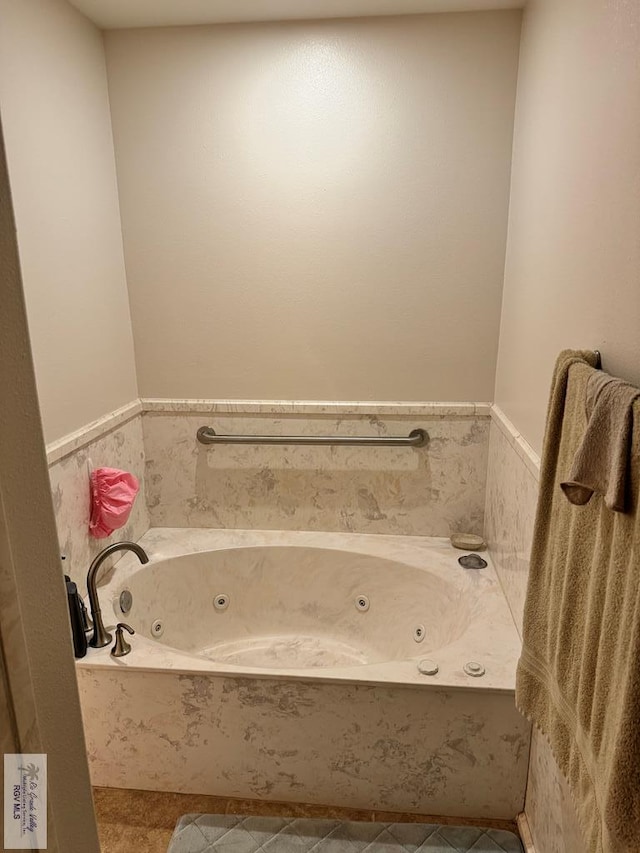 bathroom with a washtub and tile patterned floors