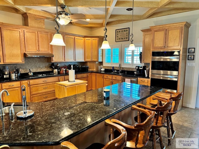 kitchen featuring pendant lighting, coffered ceiling, a spacious island, appliances with stainless steel finishes, and beamed ceiling