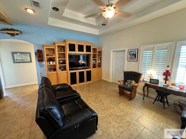 living room with light tile patterned floors, a raised ceiling, ceiling fan, and crown molding