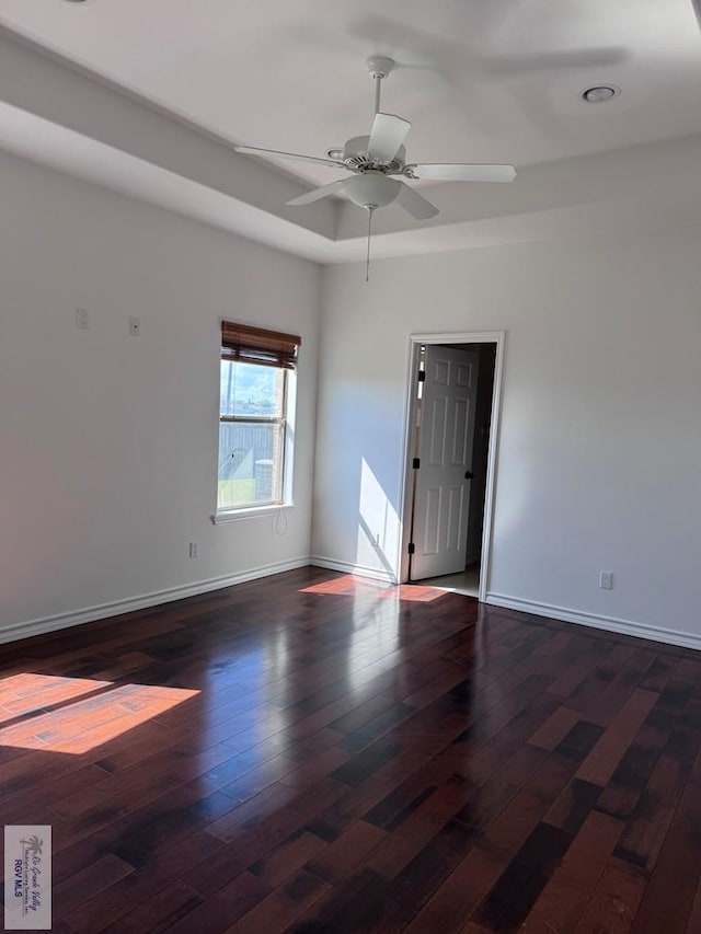 spare room featuring ceiling fan and dark wood-type flooring