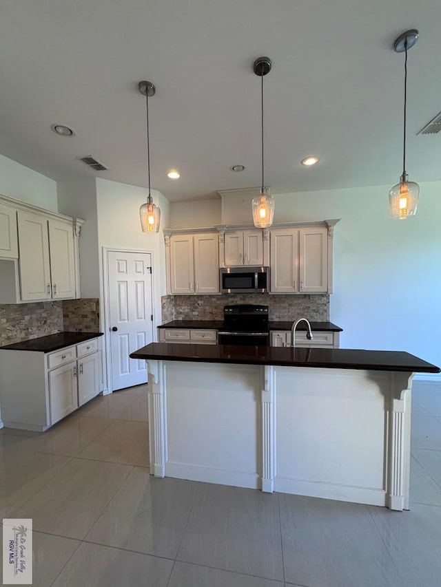 kitchen with black electric range oven, white cabinets, an island with sink, tasteful backsplash, and decorative light fixtures