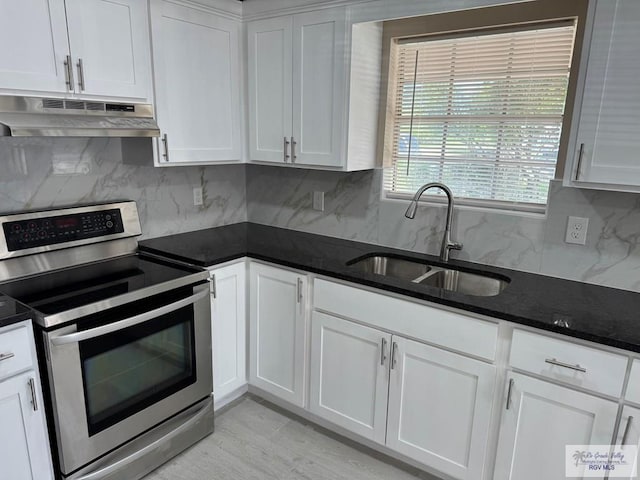 kitchen with electric range, under cabinet range hood, a sink, white cabinets, and backsplash