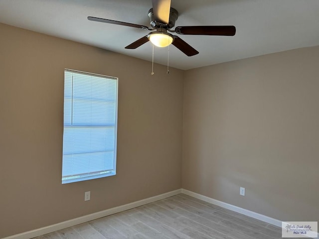 spare room featuring a ceiling fan, baseboards, and light wood-style flooring