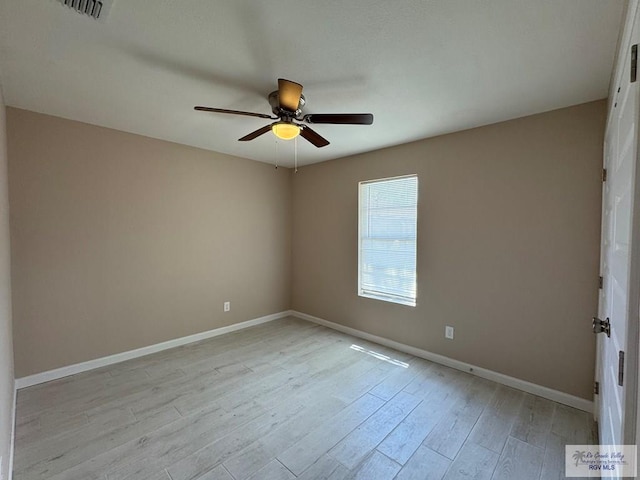 spare room with a ceiling fan, baseboards, and light wood-style floors
