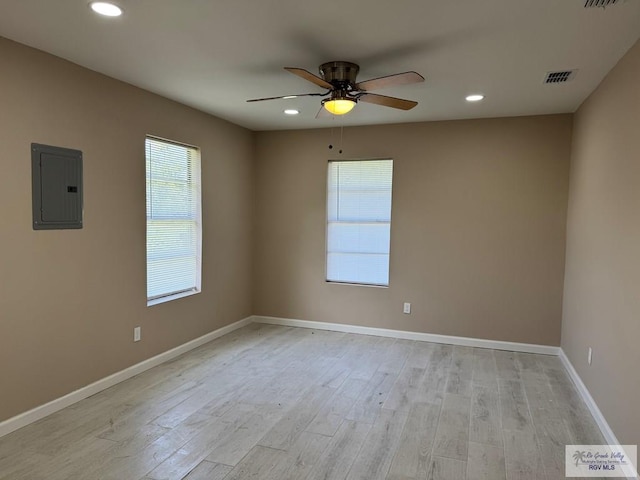 unfurnished room featuring electric panel, plenty of natural light, ceiling fan, light wood-style floors, and recessed lighting