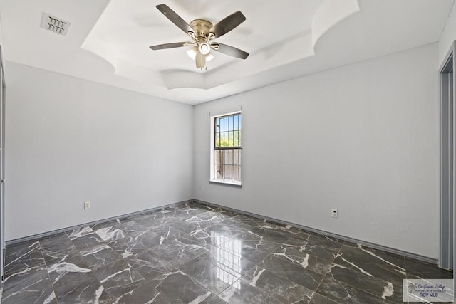 9315 Los Olmos Dr, Los Fresnos, TX 78566 - unfurnished room featuring a raised ceiling, a ceiling fan, and marble finish flooring
