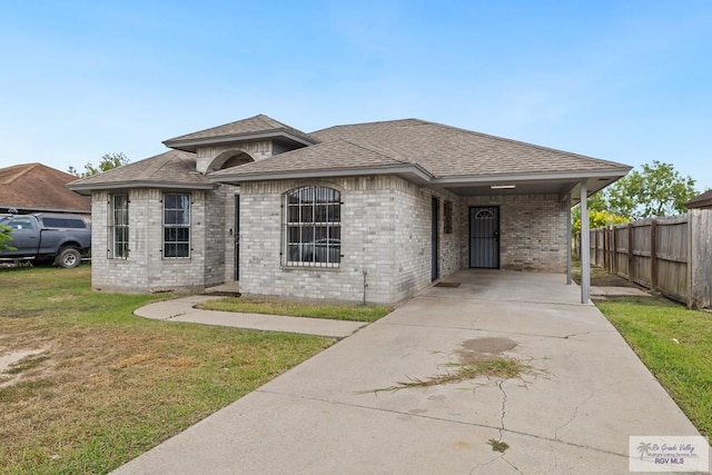 9315 Los Olmos Dr, Los Fresnos, TX 78566 - view of front of house with roof with shingles, driveway, and brick siding
