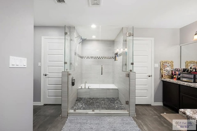 bathroom featuring vanity and shower with separate bathtub