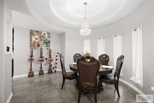 dining room featuring a chandelier and a raised ceiling