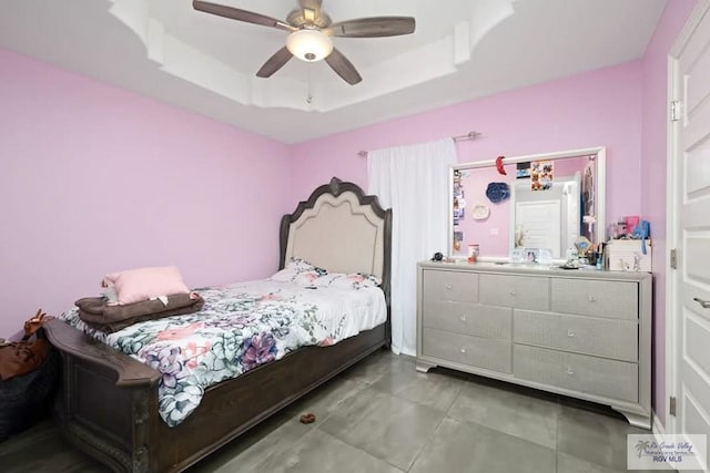 bedroom featuring tile patterned floors, ceiling fan, and a raised ceiling