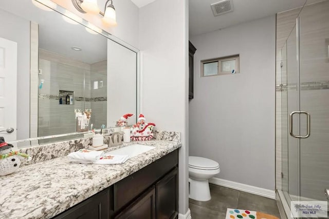 bathroom with tile patterned flooring, vanity, an enclosed shower, and toilet