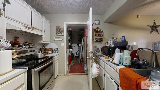 kitchen with electric stove, light countertops, white cabinets, a sink, and a textured ceiling