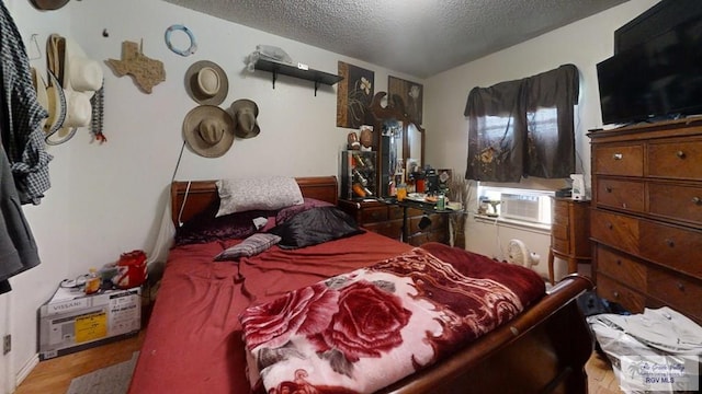 bedroom featuring a textured ceiling and wood finished floors