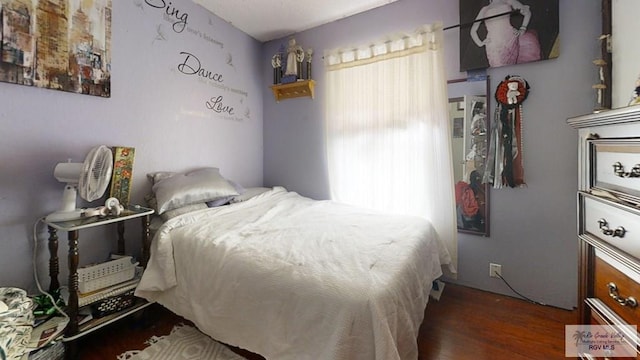 bedroom with multiple windows and wood finished floors