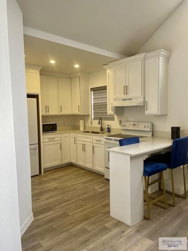 kitchen with light countertops, white cabinetry, a sink, white appliances, and under cabinet range hood