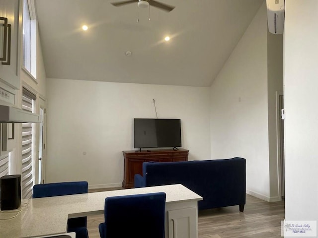 office space featuring ceiling fan, high vaulted ceiling, light wood finished floors, and baseboards