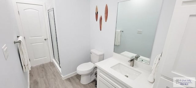 bathroom featuring walk in shower, hardwood / wood-style floors, vanity, and toilet