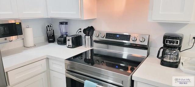 kitchen with white cabinetry and appliances with stainless steel finishes