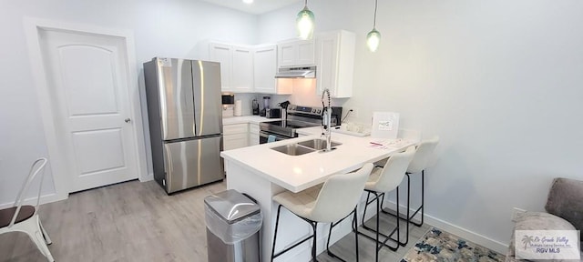 kitchen featuring kitchen peninsula, white cabinetry, stainless steel appliances, and decorative light fixtures