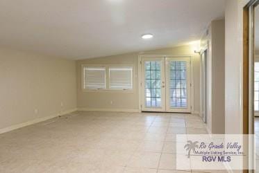 tiled spare room with french doors and lofted ceiling