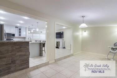 kitchen featuring white cabinetry, stainless steel appliances, kitchen peninsula, pendant lighting, and a breakfast bar area